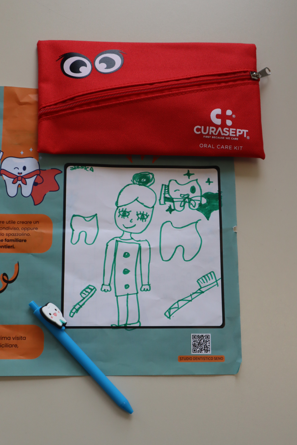 Kit Curasept e disegno di una bambina sul materiale dello studio